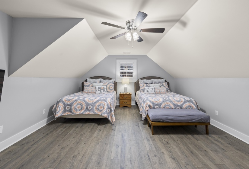 Bedroom with a ceiling fan, wood finished floors, and vaulted ceiling