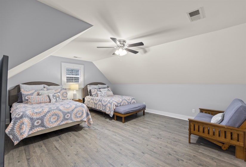 Bedroom with wood finished floors, lofted ceiling, and ceiling fan