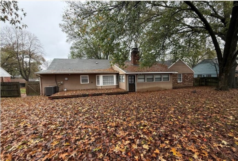 Back of property featuring a gate and a chimney