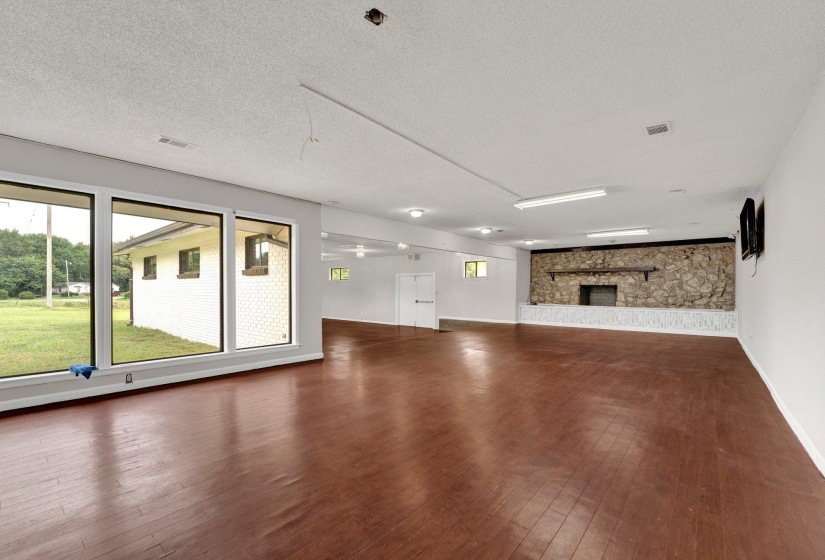Unfurnished living room with dark wood-type flooring and a textured ceiling