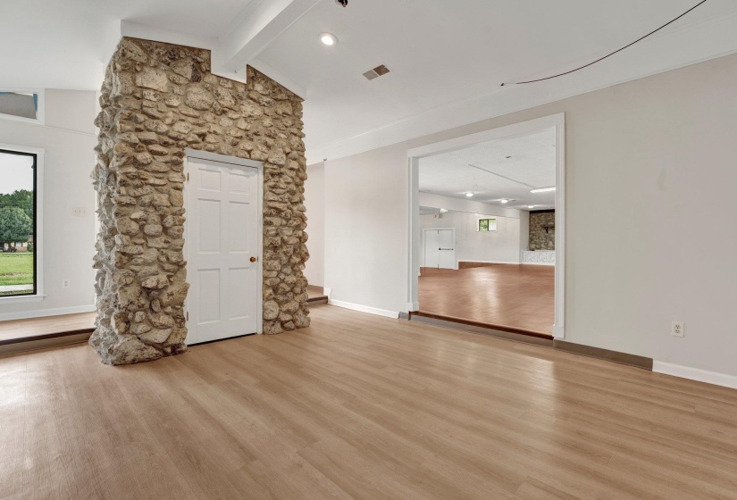 Unfurnished living room featuring light hardwood / wood-style flooring and lofted ceiling