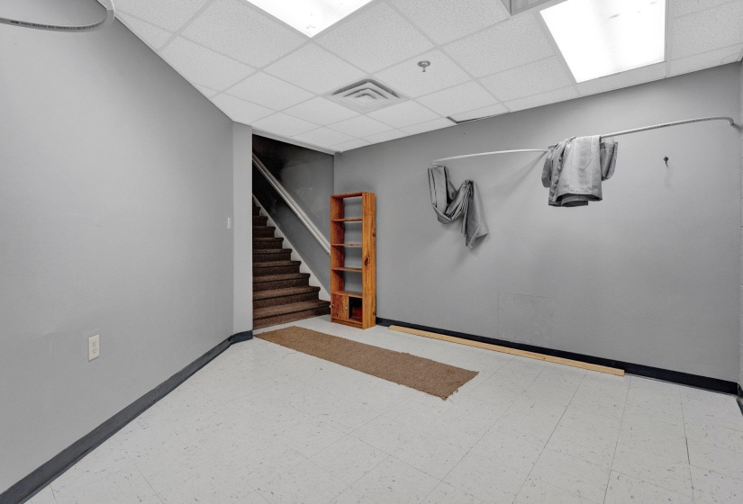 Basement with tile patterned floors and a paneled ceiling