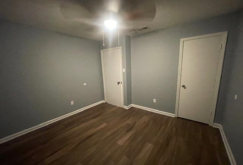 Empty room with dark wood finished floors and baseboards