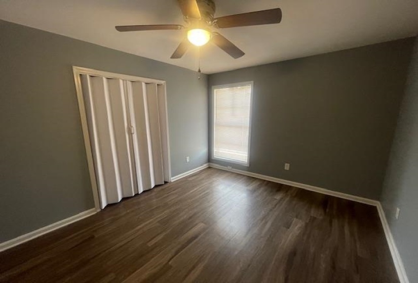 Unfurnished bedroom featuring dark wood finished floors, ceiling fan, and a closet