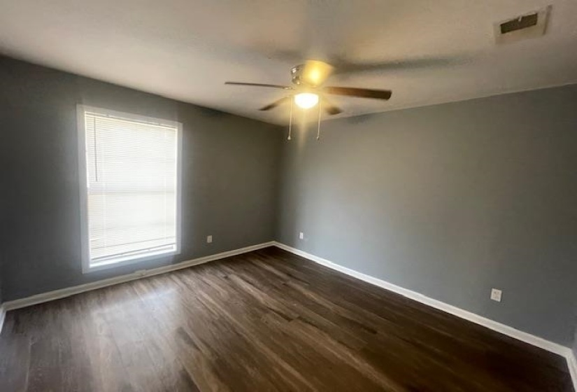 Spare room with dark wood-style floors and a ceiling fan