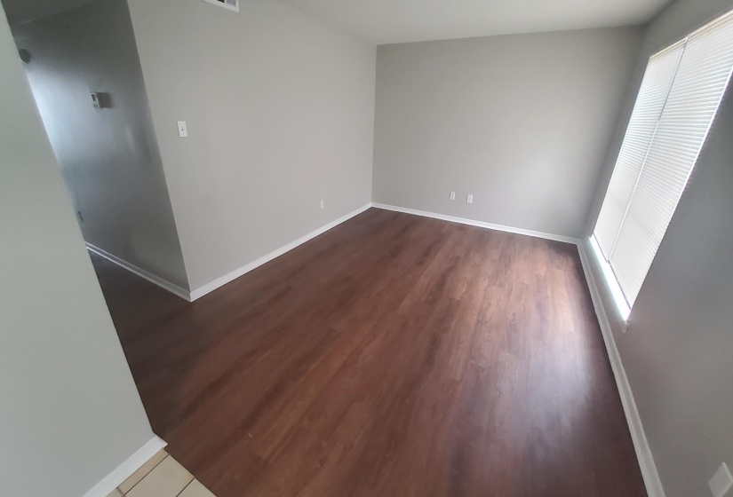 Unfurnished bedroom featuring multiple windows and wood finished floors