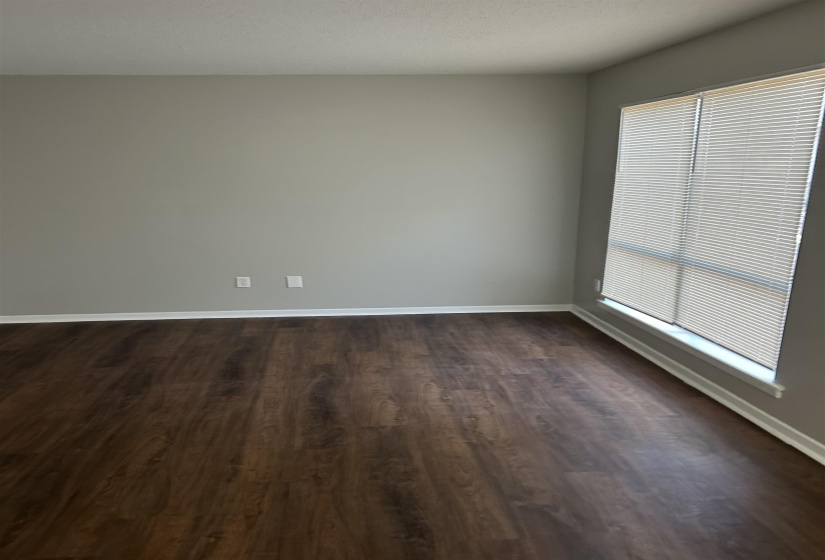 Spare room featuring a textured ceiling and dark wood-style floors