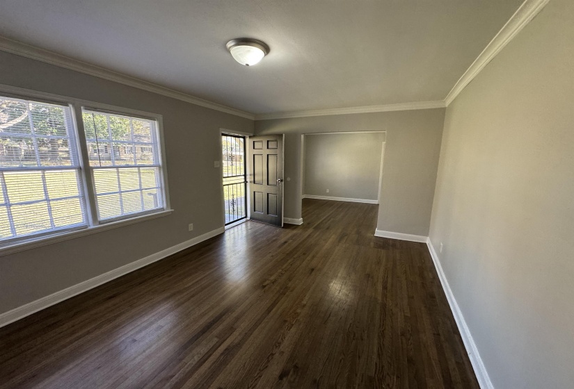 Unfurnished room featuring dark wood-type flooring and ornamental molding