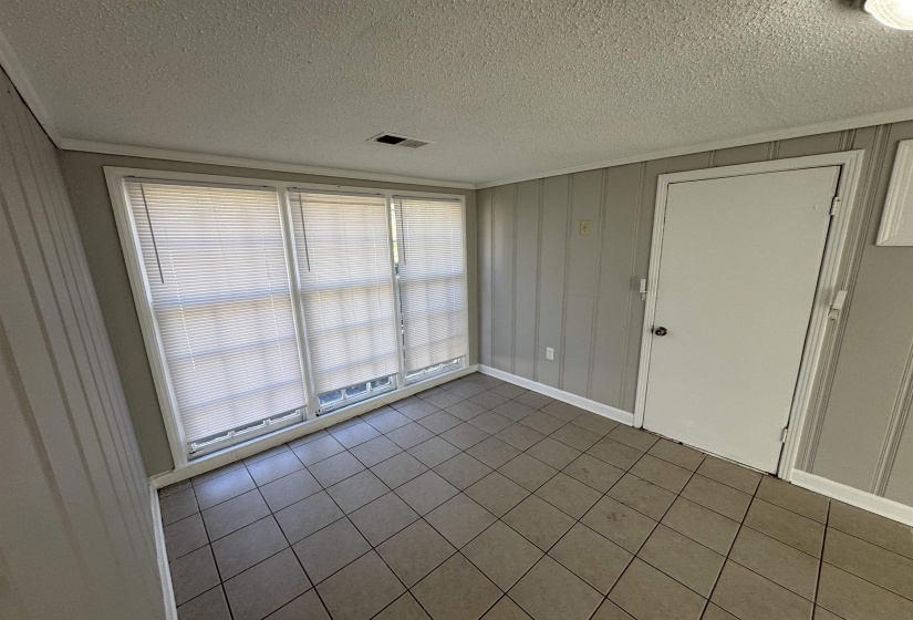 Tiled empty room featuring a textured ceiling