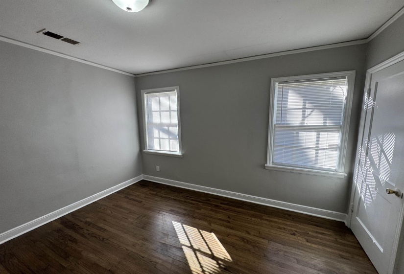 Unfurnished room featuring crown molding and dark wood-style floors