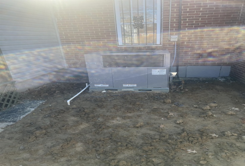 Exterior view of brick siding and a central air condition unit