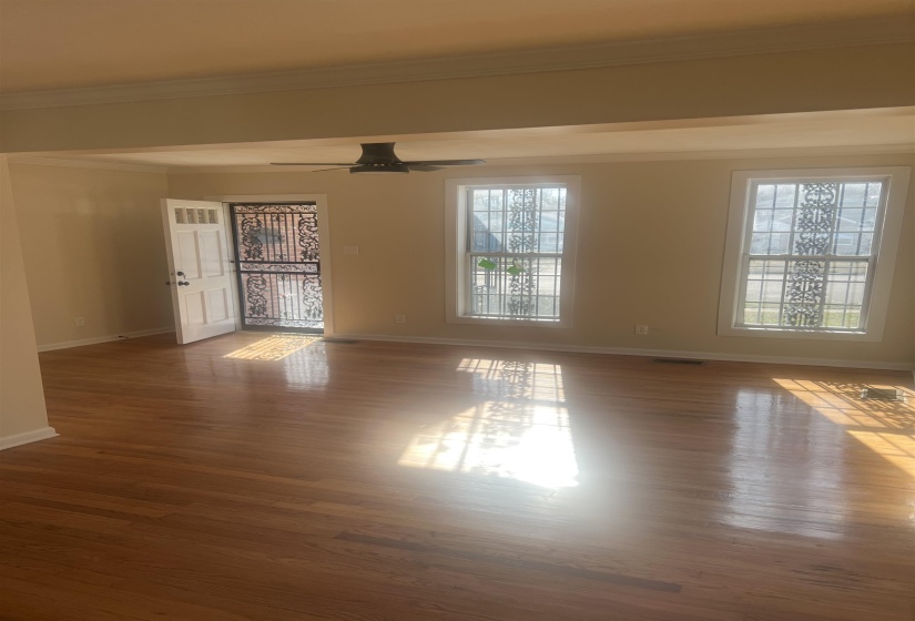 Unfurnished room featuring crown molding, wood finished floors, and ceiling fan