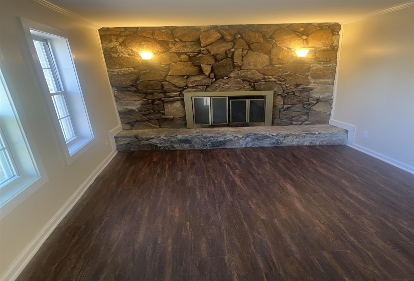 Unfurnished living room with dark wood finished floors and a fireplace