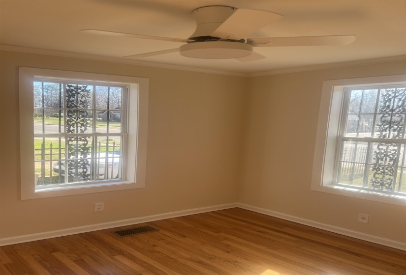 Spare room featuring crown molding, wood finished floors, and ceiling fan