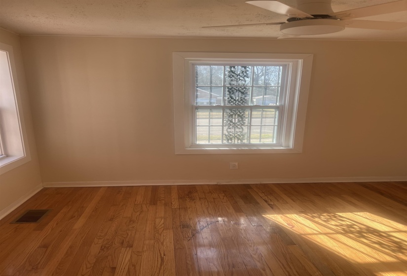 Spare room with light wood-style floors, ceiling fan, and a textured ceiling