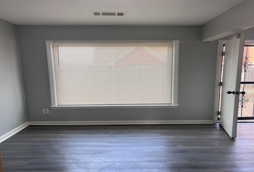 Empty room featuring dark wood finished floors and plenty of natural light