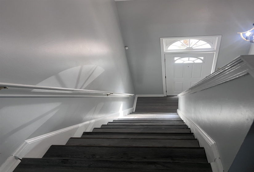 Staircase featuring baseboards and wood finished floors