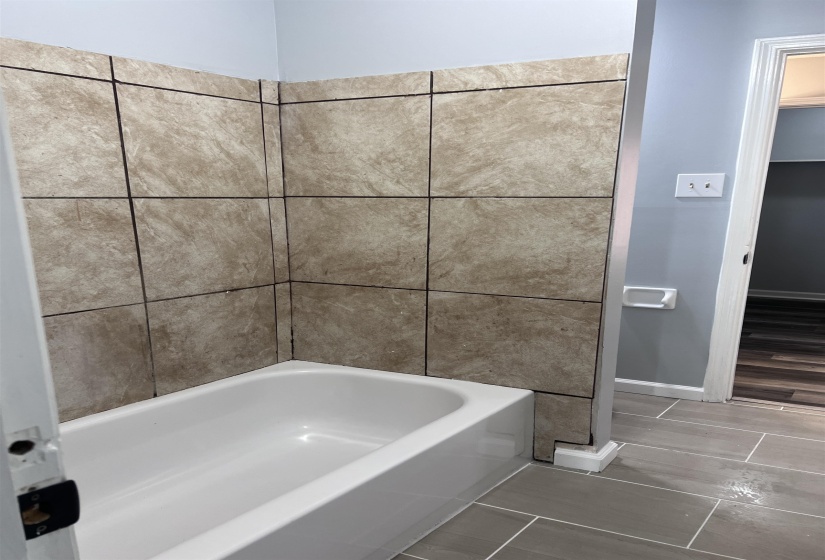 Full bath with baseboards and a tub