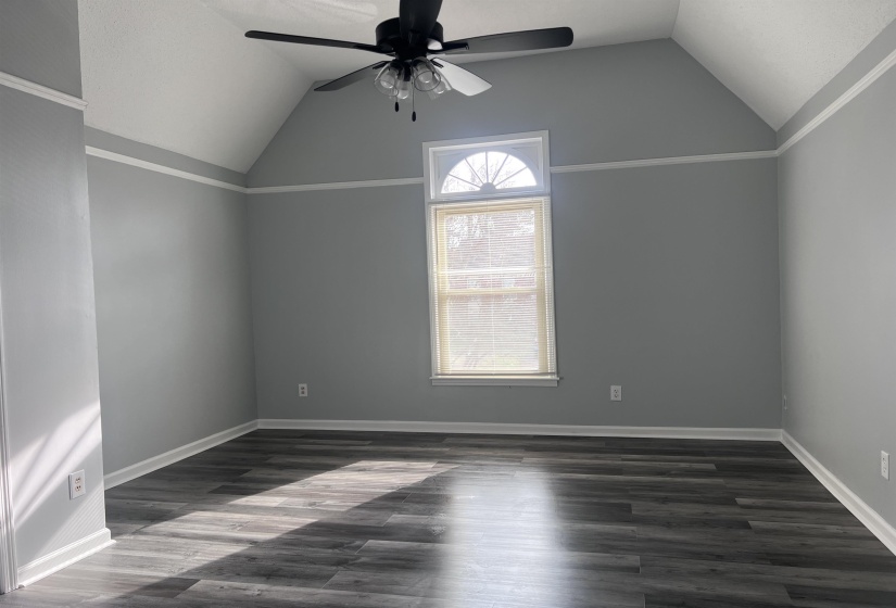 Additional living space with vaulted ceiling, dark wood-type flooring, and ceiling fan