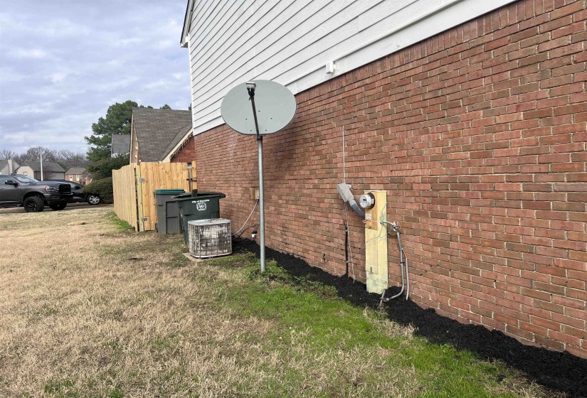 View of side of property with brick siding and a central air condition unit