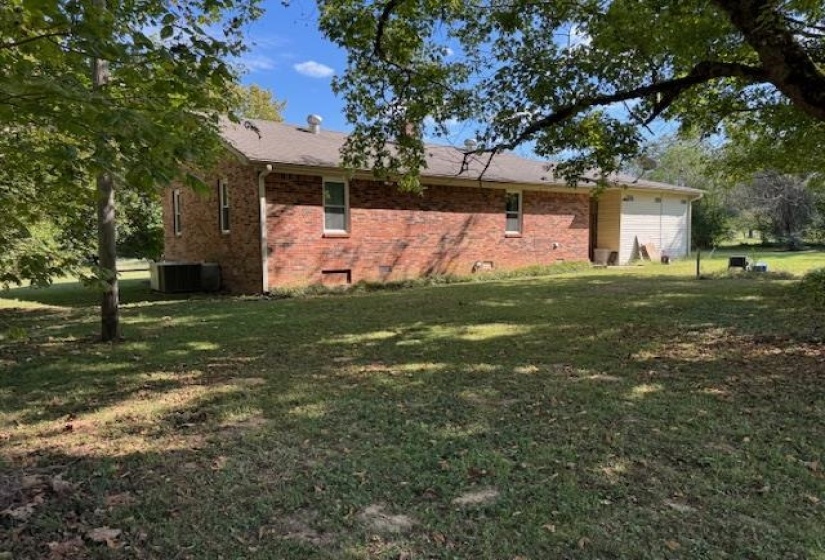 View of home's exterior with crawl space, brick siding, and a yard