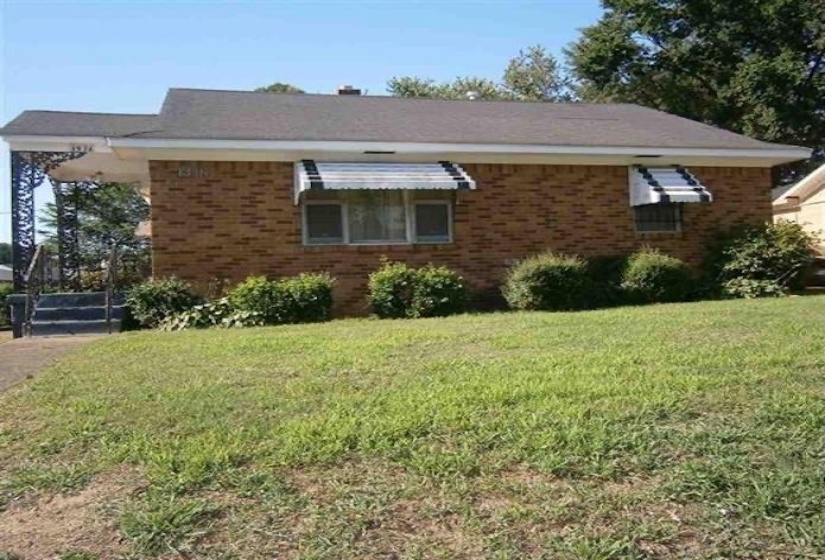 View of front of house featuring brick siding and a front lawn