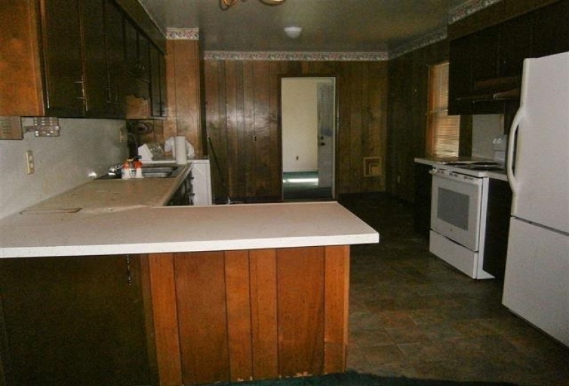 Kitchen featuring white appliances, light countertops, and a peninsula