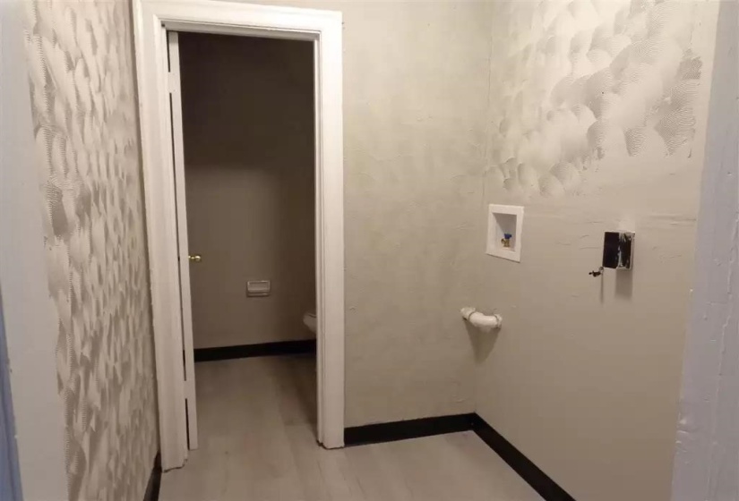 Bathroom with wood finished floors, toilet, and baseboards