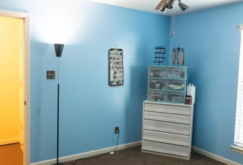 Bedroom featuring baseboards and dark carpet
