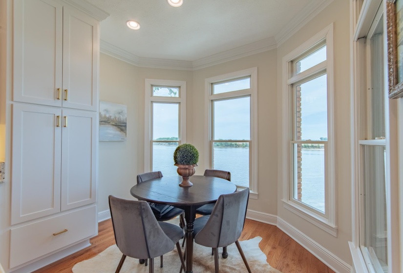Dining room featuring light wood-style floors, ornamental molding, baseboards, and a water view