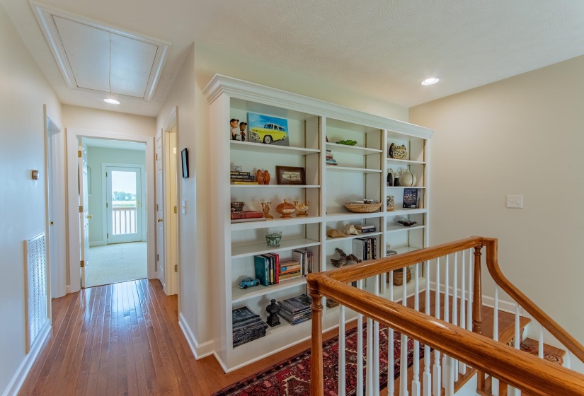 Corridor featuring attic access, visible vents, hardwood / wood-style flooring, baseboards, and recessed lighting