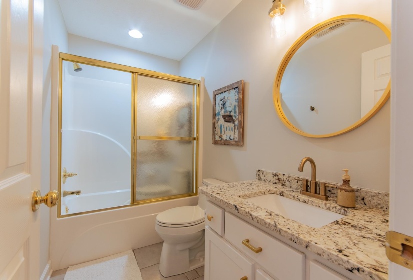 Full bath with visible vents, vanity, toilet, bath / shower combo with glass door, and tile patterned floors