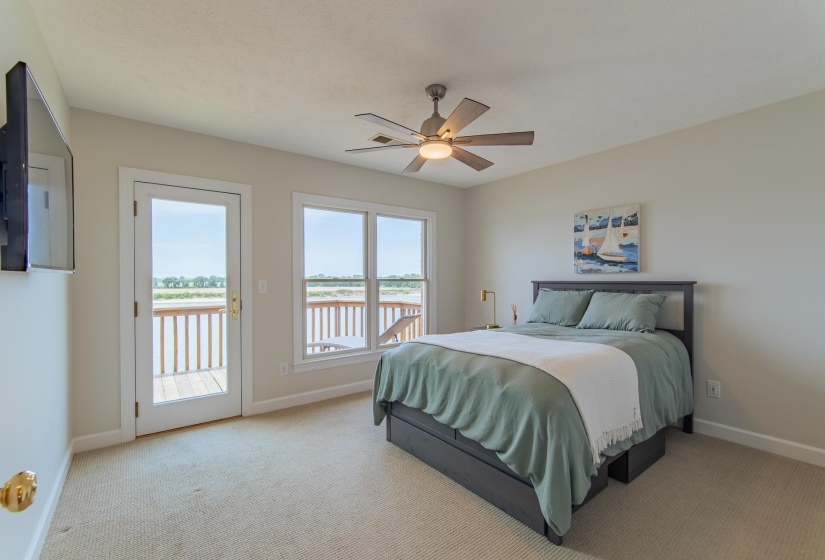 Bedroom with baseboards, carpet, a water view, and access to exterior