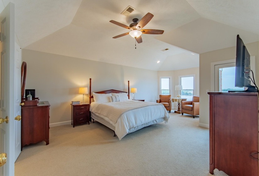 Bedroom featuring baseboards, visible vents, light colored carpet, and lofted ceiling