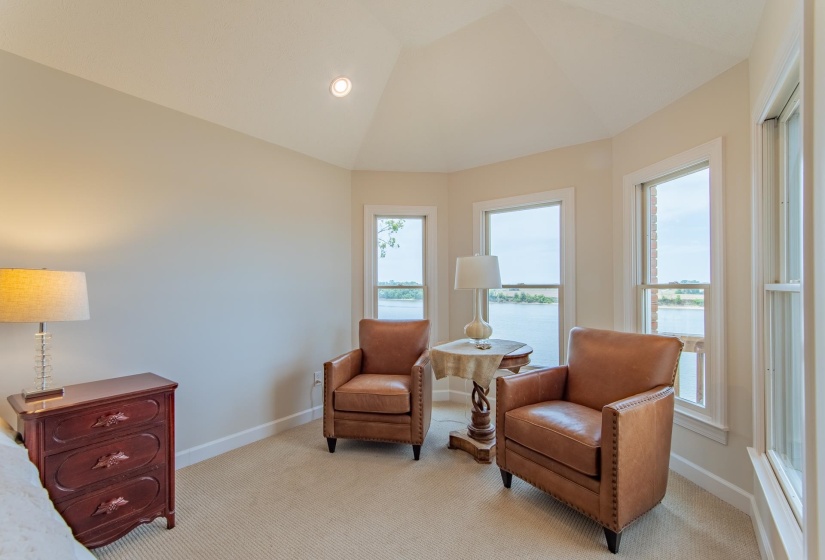 Sitting room featuring baseboards, light colored carpet, and a wealth of natural light