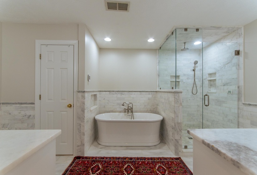 Bathroom featuring visible vents, a wainscoted wall, a shower stall, and tile walls