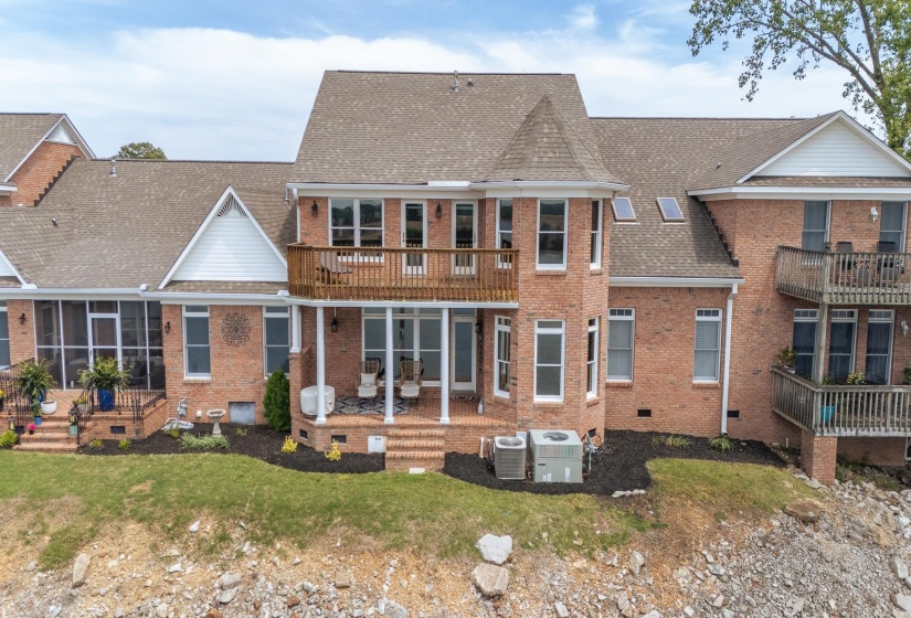 Back of property featuring a shingled roof, a sunroom, crawl space, and brick siding