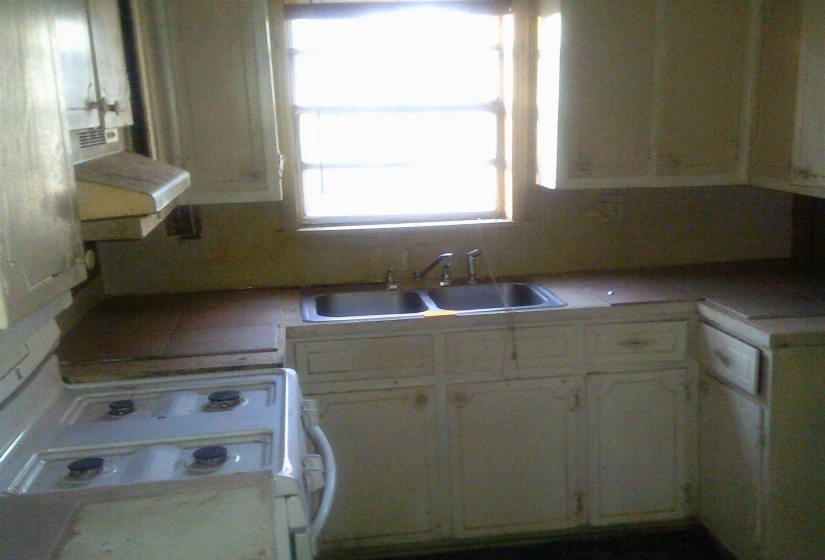 Kitchen featuring ventilation hood, white range oven, and tile counters