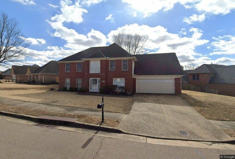 Colonial home featuring concrete driveway, an attached garage, and brick siding