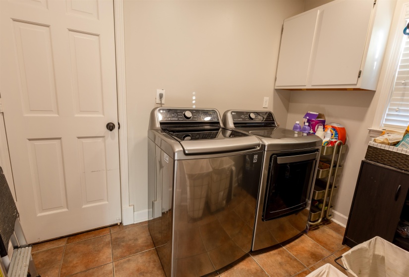 Laundry room featuring cabinet space, separate washer and dryer, and tile patterned flooring