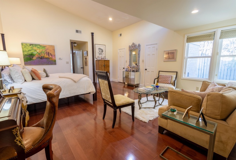 Bedroom with dark wood finished floors, vaulted ceiling, and recessed lighting