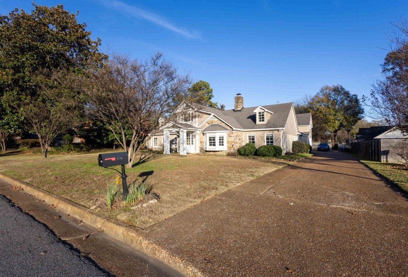 View of front facade with a chimney and driveway