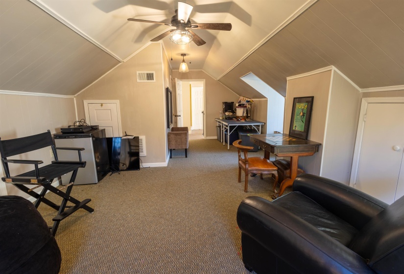 Interior space with light carpet, lofted ceiling, and a ceiling fan