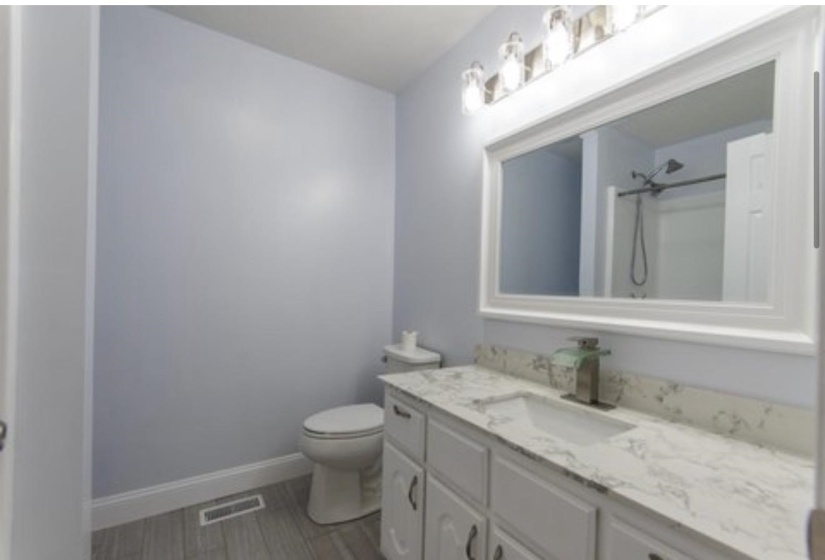 Bathroom featuring vanity and a shower