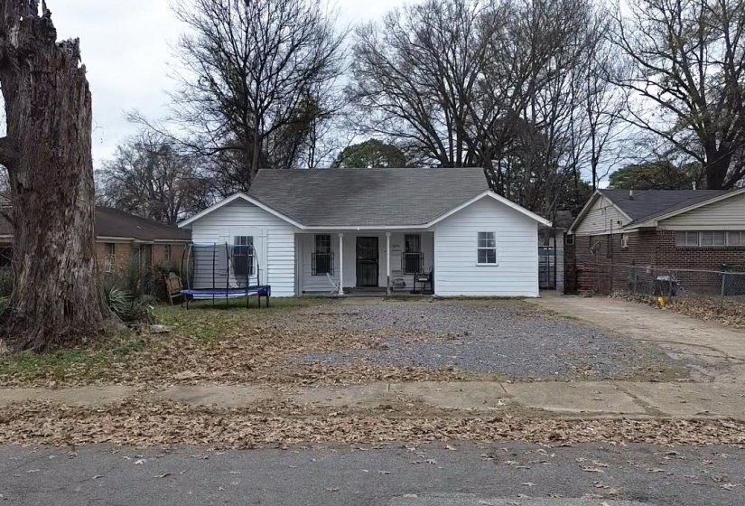 Ranch-style house featuring a trampoline, covered porch, and driveway