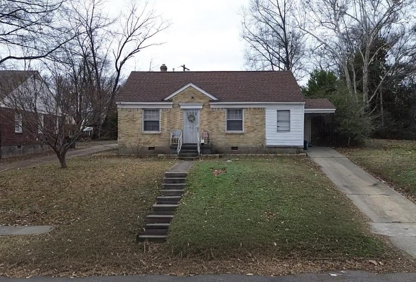 View of front facade featuring crawl space, brick siding, roof with shingles, a front lawn, and a chimney
