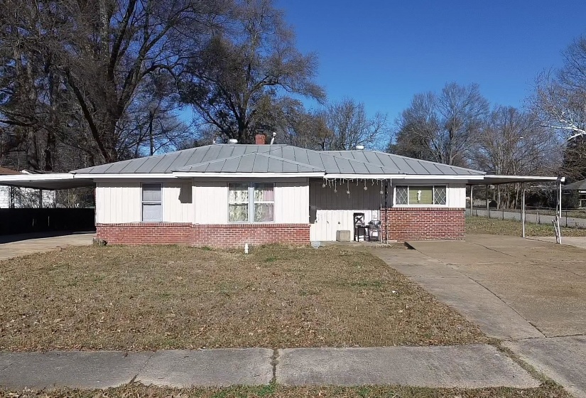 View of front of property with a carport, driveway, and brick siding