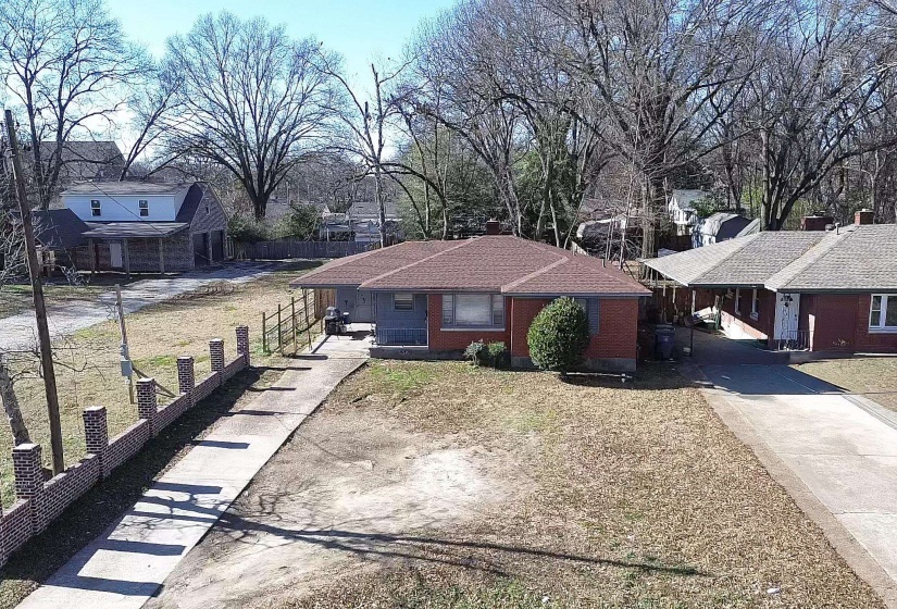 Ranch-style house with driveway, brick siding, a chimney, and a residential view