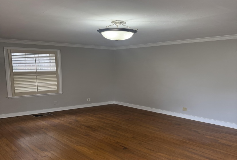 Unfurnished room featuring crown molding and dark wood-type flooring