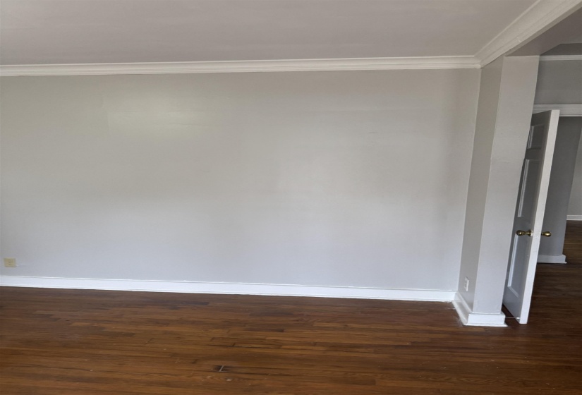 Unfurnished room featuring crown molding and dark wood finished floors